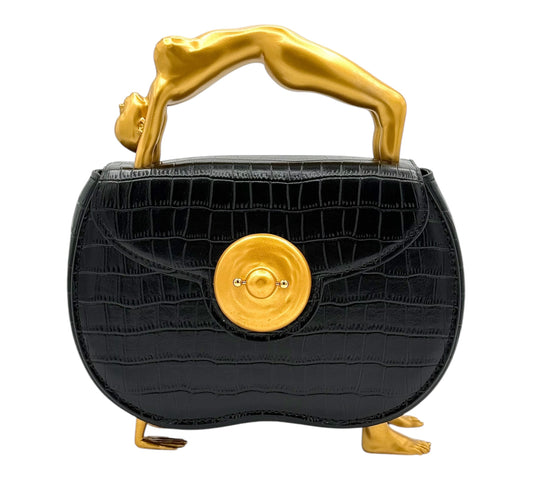 Black handbag with female gold handle and decorative elements .